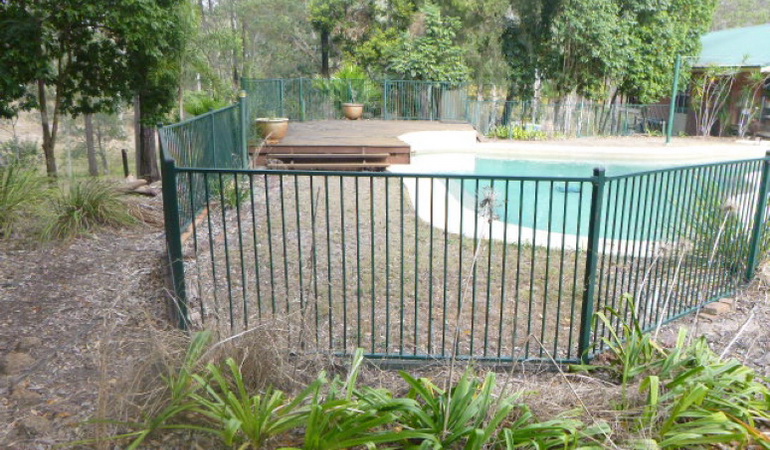 outdoor swimming pool with green aluminium fencing