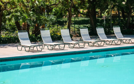 A residential backyard swimming pool with a textured deck, illustrating a typical installation and its potential cost.
