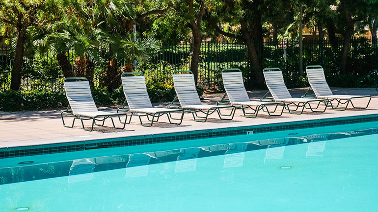 A residential backyard swimming pool with a textured deck, illustrating a typical installation and its potential cost.