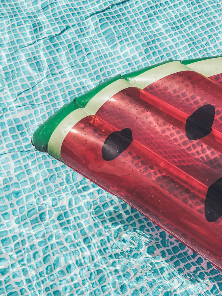 Inflatable watermelon float in a swimming pool.