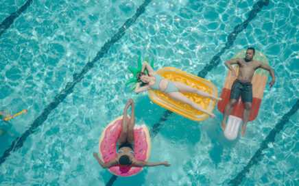People relaxing on inflatable floats in a swimming pool.